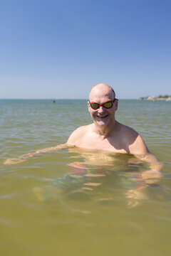 Male open water swimmer wearing goggles smiling in portrait