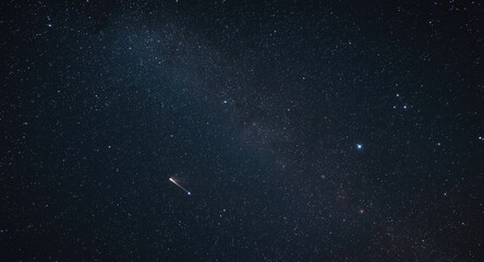 Naklejka premium Meteor crossing the dense starscape of the Milky Way at night