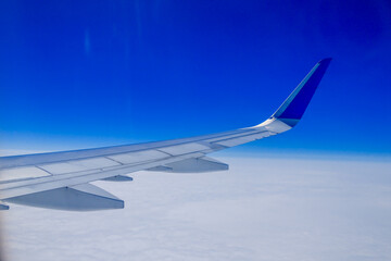 a view from the window of an airplane's wing flying above the clouds