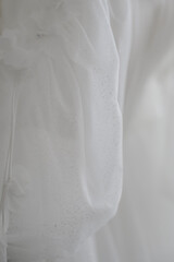 Obraz premium Close-up of delicate white fabric with floral embellishments and shimmer