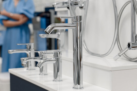 Modern chrome faucets displayed on a countertop in a bathroom showroom