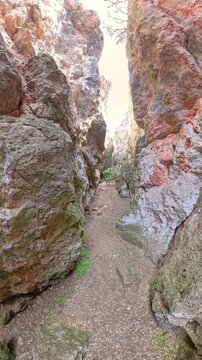 Exploring a narrow, winding hiking path through the natural rock walls of Quebrada del Toro canyon, part of the Lagunas de Ruidera Natural Park in Ossa de Montiel, Albacete, Castilla La Mancha, Spain.