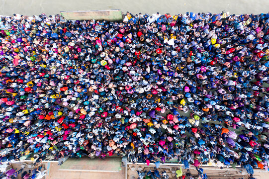 Aerial view of a sea of people, their vibrant clothing creating a mosaic of color against the backdrop of the landscape, Mawa, Dhaka Division, Bangladesh.