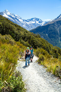 Two caucasian women hiking, or tramping, along the Routeburn Track