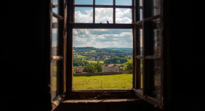 Rustic countryside townscape seen through old fashioned window with sunlight