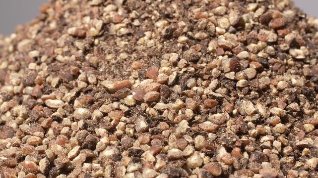 Extreme macro texture of coarse ground black pepper rotating background