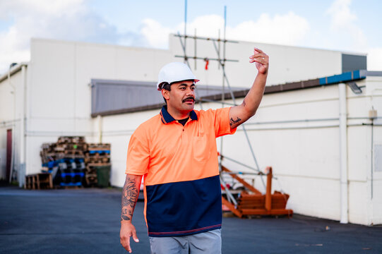 Samoan man in high vis clothing giving hand signals