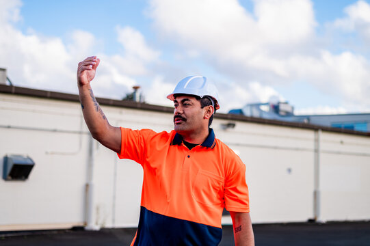 Samoan man in high vis clothing giving hand signals