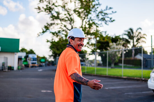 A cheerful construction worker in a hard hat and hi-vis shirt