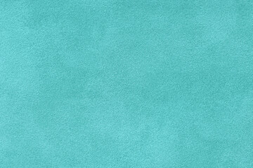 Fototapeta premium Light turquoise suede fabric background with matte nap velvet texture. Cyan tones and soft felt textile surface in macro