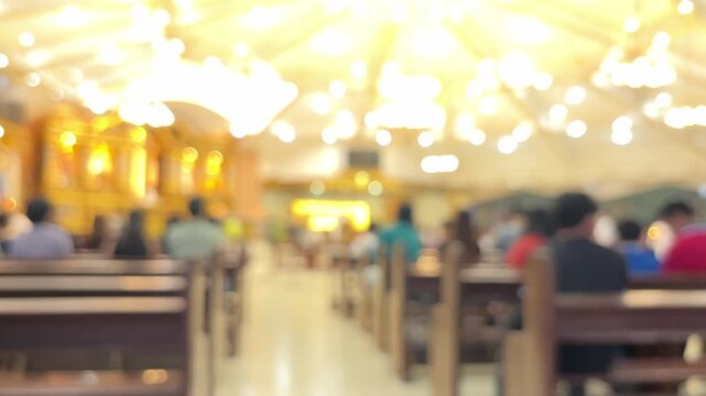 Interior view of catholic church with congregation during religious mass service, blurred bokeh of people in pews