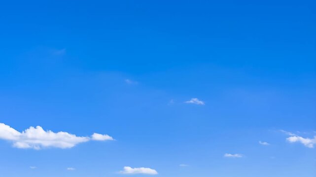 Time lapse aerial view of clouds drifting across clear blue daytime sky over open horizon