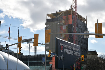 Naklejka premium Varsity Blues sign at Varsity Stadium and construction of The Academic Wood Tower (110 Devonshire Place), Toronto