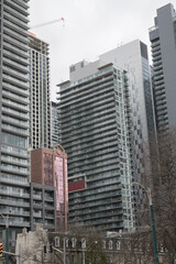 Naklejka premium looking northeast from Spadina Av near Clarence Square with historic row houses (bottom) and condos incl King's Tower (393 King St W), Toronto