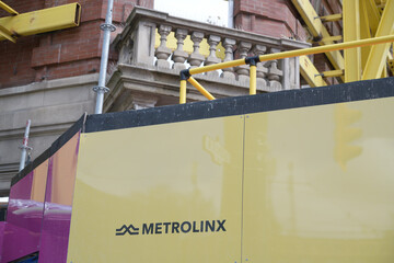 Naklejka premium hoarding outside construction site of future Queen-Spadina station, Ontario Line, with logo sign of Metrolinx, Toronto
