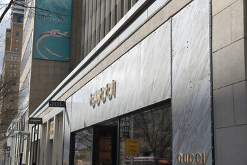 Naklejka premium perspective view of exterior building facade and sign of Gucci, a fashion boutique, located at 130 Bloor St W, Toronto