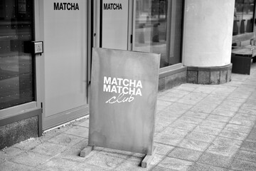 Naklejka premium black and white view of sidewalk sign outside MATCHA MATCHA, a cafe, located here at 294 Dundas St W, Toronto