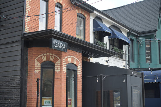 exterior building facade and sign outside SARA, a restaurant, located at 98 Portland St, Toronto