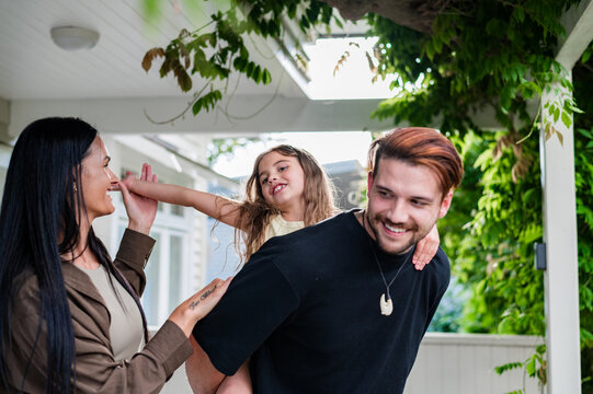 A family consisting of a mother, father, and a daughter having fun together