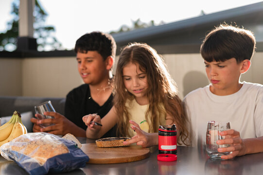Young girl with long hair spreading marmite on a slice of bread