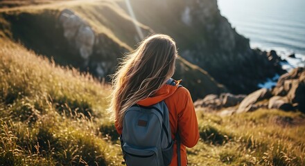 Naklejka premium Woman hiking on a cliffside trail with a scenic ocean view