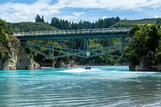Jet boat going under historic Rakaia Gorge Bridge