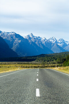 Low angle of bitumen road towards snow-capped mountains