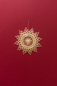 Straw snowflake. Snowflakes are made of straw on a red background. Christmas decor. Top view. Straw weaving. Lutsk, Ukraine