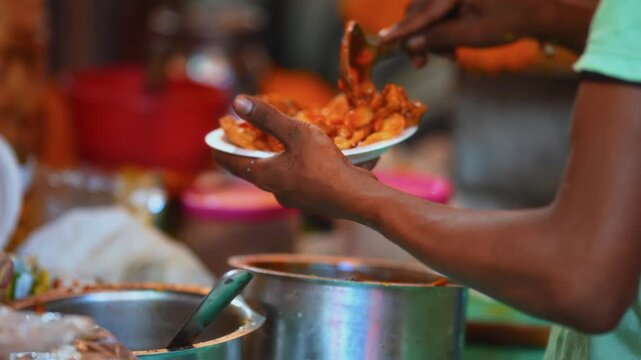 Chaat Close view of hands preparing fresh Indian food in a local street shop, showing authentic cooking process and traditional flavors.