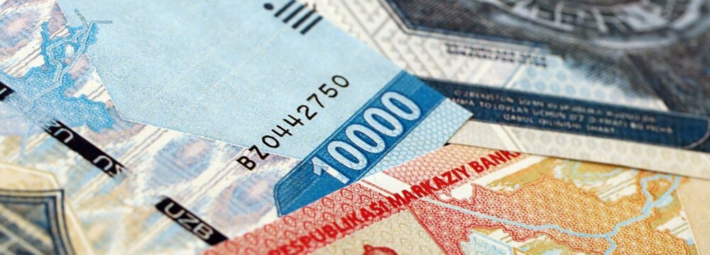Uzbek som money bills pile on table. Uzbekistan banknotes of UZN currency close up. Concept of business, economy and banking in Uzbekistan