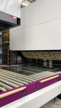 A conveyor belt with new window glass at a modern factory. Production cycle, automated factory line, manufacturing process