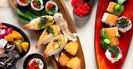 A table with Asian food, sushi, rolls, desserts. © bit24