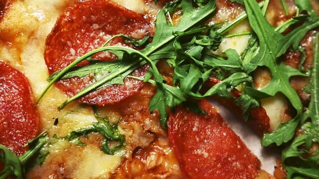 Pepperoni pizza texture with fresh arugula, top view Italian cuisine background