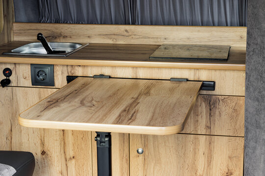 Camper van interior with wooden furniture and compact living space