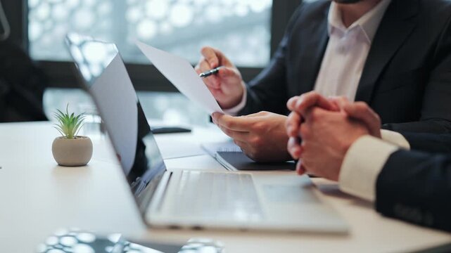 Business meeting with two professionals reviewing documents. Focus on serious discussion, planning, and agreement. The atmosphere is calm fostering effective collaboration and decision-making.