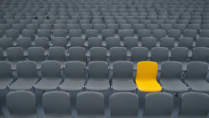 Fototapeta premium Yellow chair in a sea of gray chairs