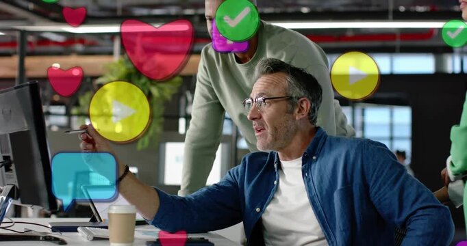 Vertical video: Seated man pointing at screen team leaning social icons rising hiding view for ads