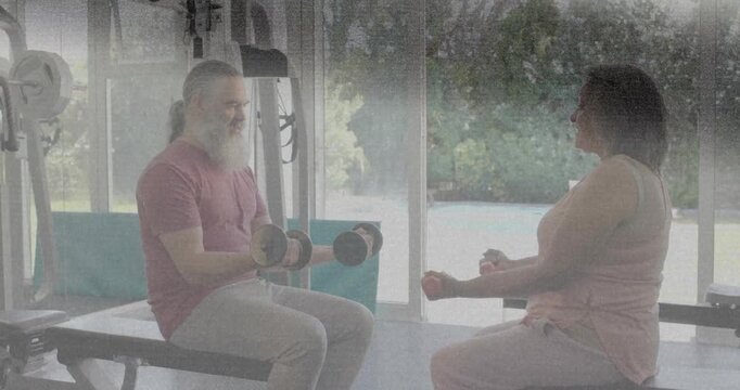 Man and woman doing bicep curls, lifting dumbbells to raise arms low to high, building fitness