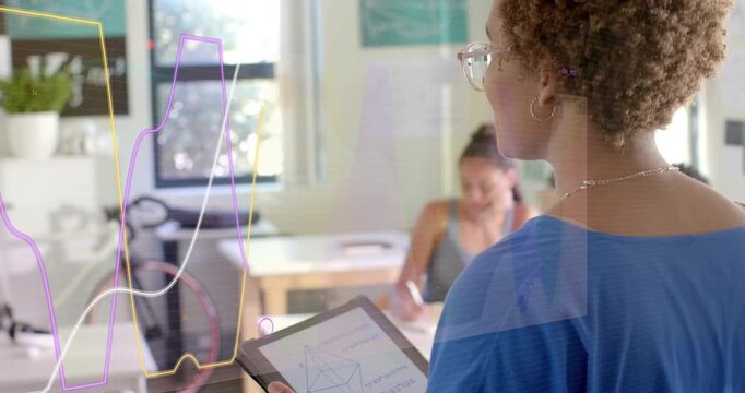 Teacher raising tablet and turning toward students showing flowing graph overlays to explain data