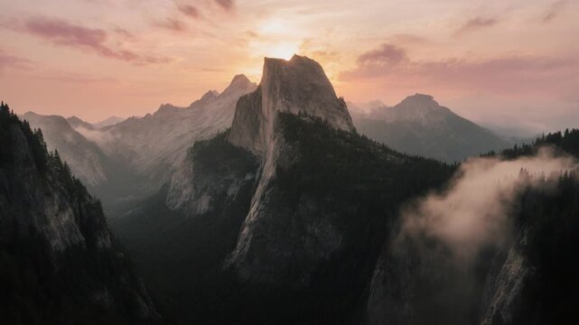 Majestic mountain peak at sunrise, with foggy valleys and sunrise in background, ideal for travel or nature use