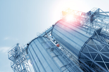 Industrial farm agricultural silos for storage and drying of grains, wheat, corn, soy, sunflower with sunlight. © Parilov