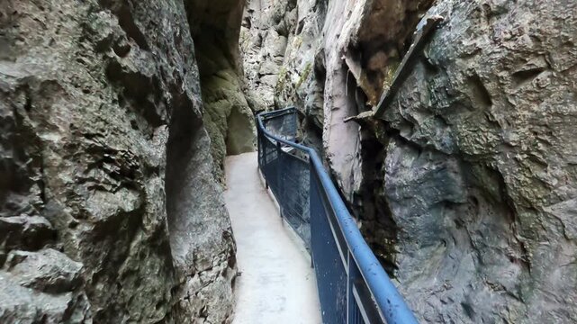 Pasarelas met&aacute;licas del desfiladero de Desfiladero de La Yecla, un espectacular ca&ntilde;&oacute;n natural rodeado de altas paredes rocosas. La escena muestra el recorrido a trav&eacute;s de estrechos pasillos suspendido