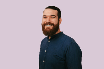 Obraz premium Bearded Caucasian Man Smiling Warmly Casual Navy Shirt Studio Headshot Conveying Approachable Confident