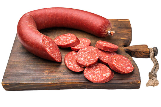 Whole and sliced Turkish sucuk (sujuk) on a rustic cutting board. Traditional spicy dry-cured sausage.