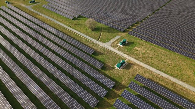 Aerial drone view of solar panels and green BESS battery storage units in a rural UK field
