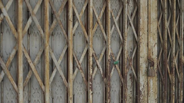 Close up corroded metal gate with geometric pattern, aged industrial surface texture