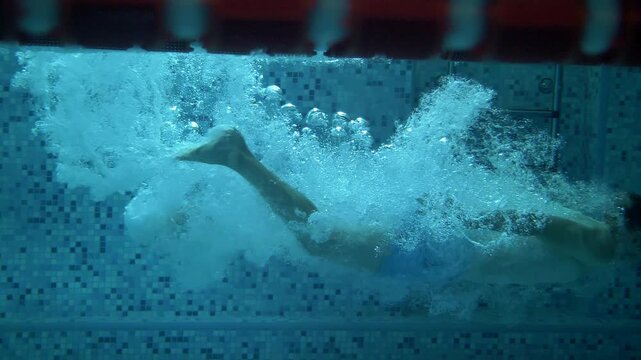 Man in swimming shorts slowly sinking into water in slow motion