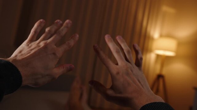 Point of View. A man lying on the bed examines his hands and playfully fools around.