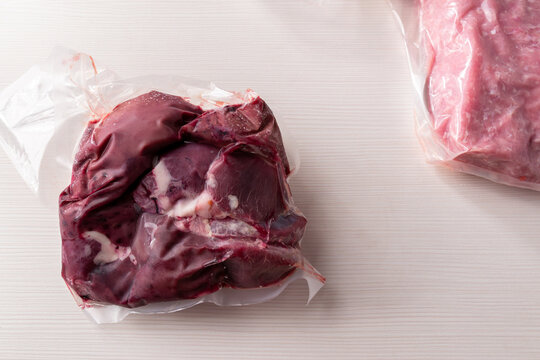 Organic raw turkey offal and ground meat in vacuum sealed bags, frozen bio poultry giblets for healthy meal prep.