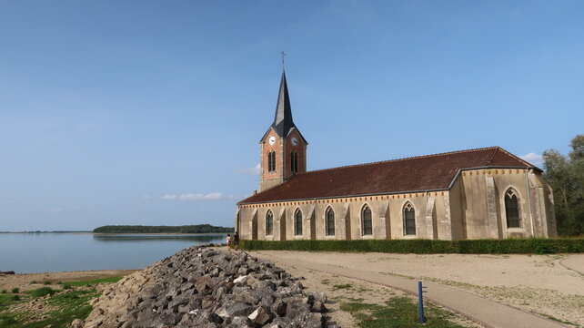 Vue sur l&rsquo;&eacute;glise de Champaubert au bord du lac du Der Chantecoq, en Champagne Ardenne, dans la r&eacute;gion Grand Est, sous un ciel bleu (France)